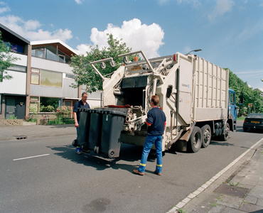 822833 Afbeelding van een nieuwe vuilniswagen met twee medwewerkers van de Gemeentelijke Reinigings-, Markt- en ...